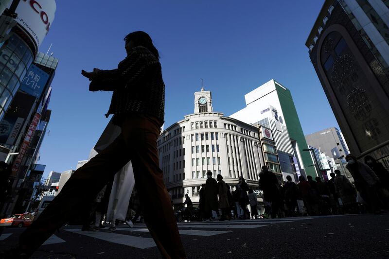 People wearing protective masks to help curb the spread of the coronavirus use a pedestrian crosswalk at the Ginza shopping street  in Tokyo.AP Photo