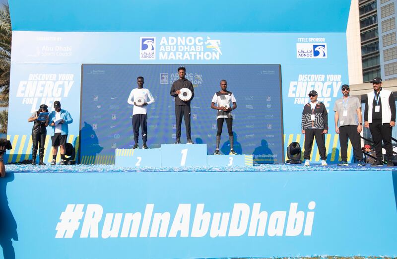Winners of the Abu Dhabi Marathon elite men's race - Amare Hailemichael Samson, center, Leornard Barsoton, left, and Ilham Ozbilan
