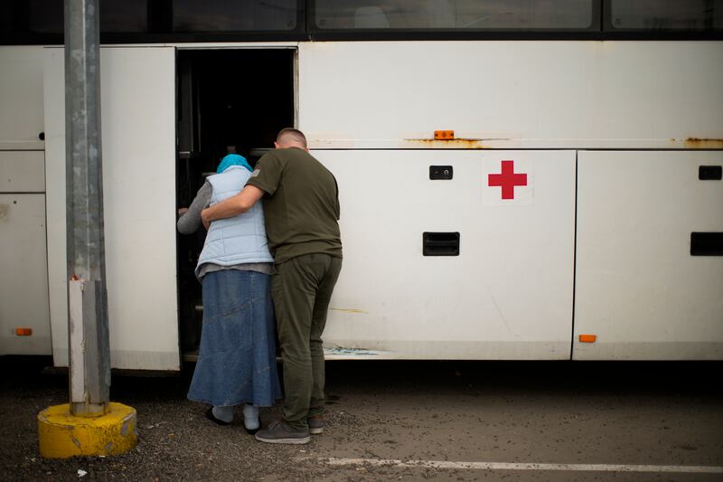 A driver helps a woman board a bus at a reception centre for displaced people in Zaporizhzhia, Ukraine. AP
