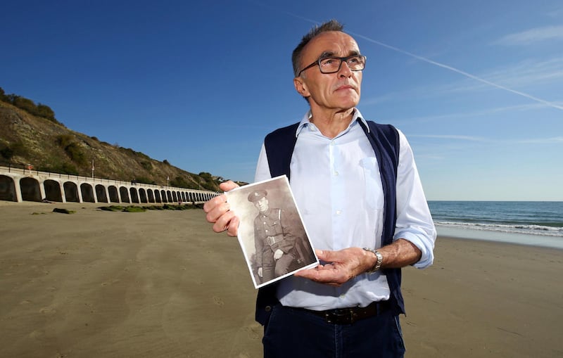 British filmmaker  Danny Boyle holds a photograph of Private Walter Bleakley, who lived on the same street where Boyle went to school, as he announces plans for his Armistice Day commission for 14-18 NOW, the UK's arts programme for the First World War centenary, on the beach, in Folkestone, England, Friday Oct. 5, 2018. Boyle is urging thousands of people to gather on British beaches and make silhouettes in the sand on Nov. 11 to mark 100 years since the end of World War I. Artists will also create giant portraits of people killed in the war, which will be washed away by the incoming tide. The commemoration caps four years of cultural activities marking the centenary of the 1914-18 conflict, in which 20 million people died. (Gareth Fuller/PAvia AP)