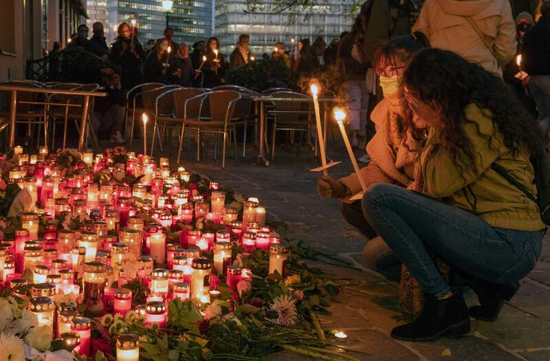 People look at tributes to the victims. AFP