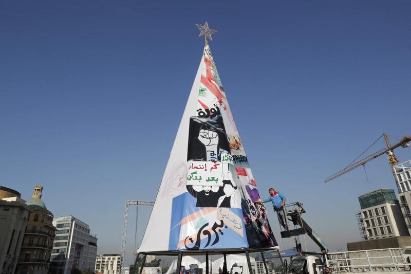 Lebanese anti-government protesters erect a Christmas tree made of protest banners in Beirut's Martyr Square.  AFP