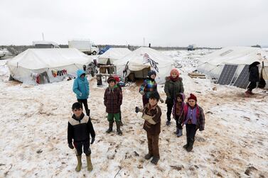 Internally displaced children stand on snow near tents at a makeshift camp in Azaz, Syria February 13, 2020. Reuters