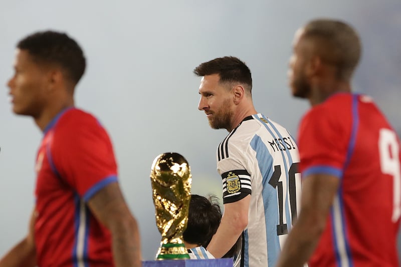 Lionel Messi of Argentina enters the pitch and passes next to the World Cup. Getty Images