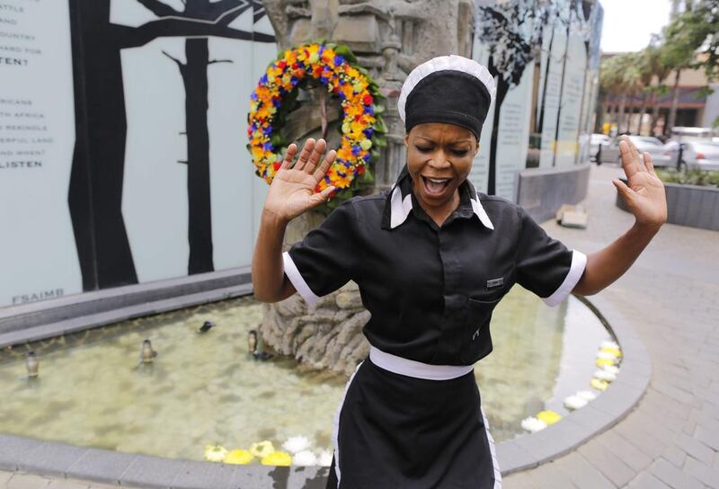 A women sings in front of a statue of Nelson Mandela during a memorial in Johannesburg.  EPA/KIM LUDBROOK Kim Ludrook / EPA