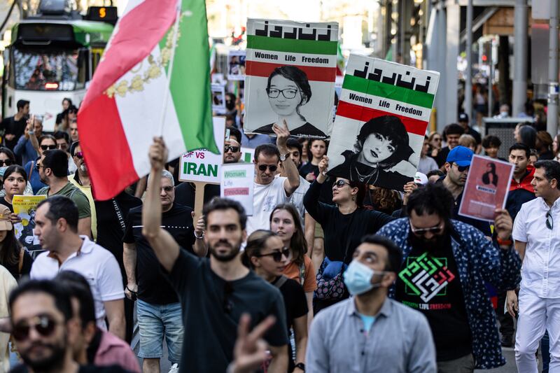 Protesters hold placards and flags during a rally marking the one-year anniversary of Mahsa Amini's death in custody, along Swanston Street, in Melbourne, Australia. EPA
