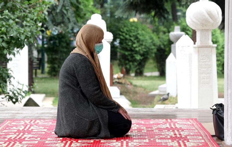 A Bosnian Muslims woman with face mask, prays in front of the Mosque, during Muslims' holy month of Ramadan, in Sarajevo, Bosnia and Herzegovina.  EPA