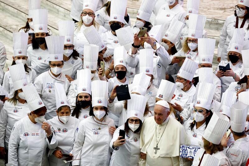 Pope Francis poses with members of Italian Chefs Federation during the weekly general audience at the Paul VI Hall at the Vatican, March 23, 2022.  REUTERS / Yara Nardi