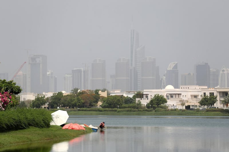 Dubai, United Arab Emirates - July 18, 2019: Weather. Men work to fix a fountain on a hot humid day in Dubai. Thursday the 18th of July 2019. The Springs, Dubai. Chris Whiteoak / The National