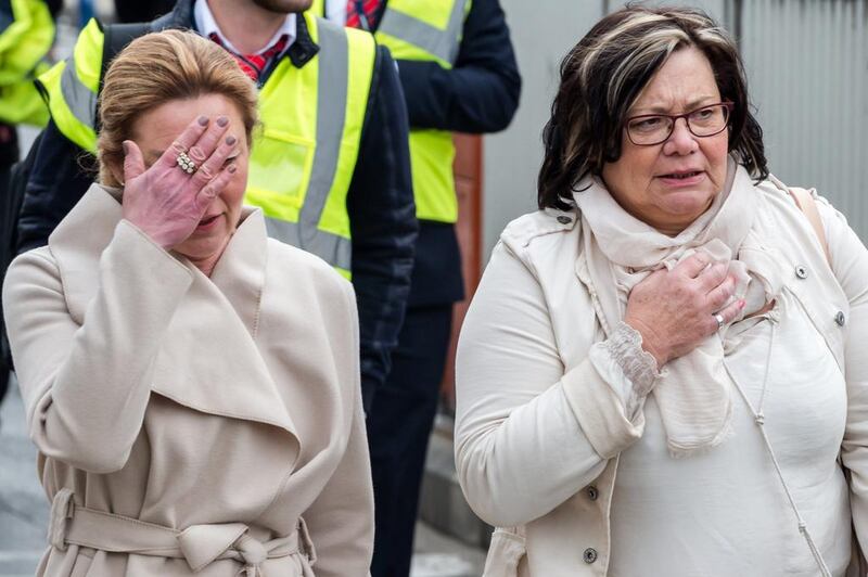 People react as they walk away from Brussels airport after explosions rocked the building in Brussels, Belgium. The Belgian capital is in lockdown after two explosions at Brussels airport and another at a metro station. Geert Vanden Wijngaert / AP