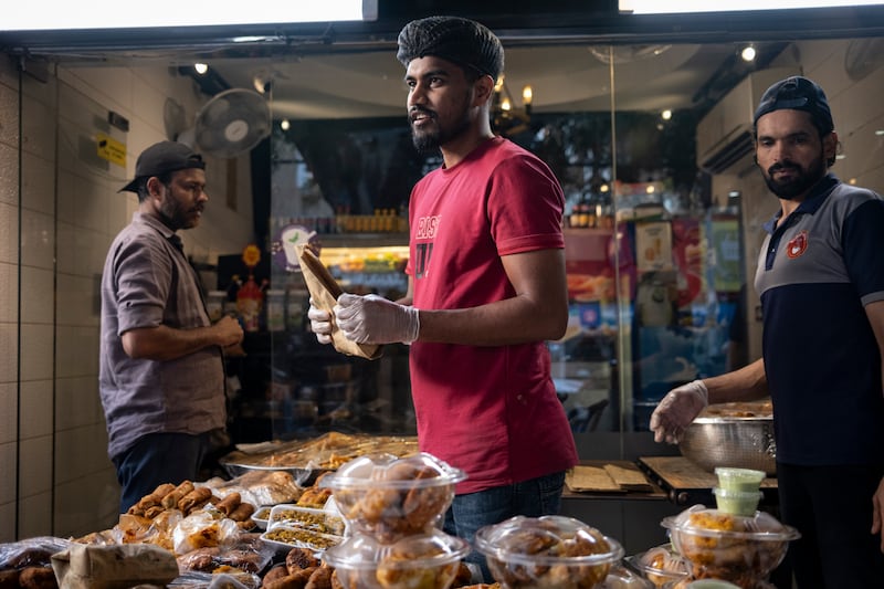 Restaurant staff sell Subcontinent street food to patrons on the streets of Bur Dubai as Iftar approaches.
Antonie Robertson/The National