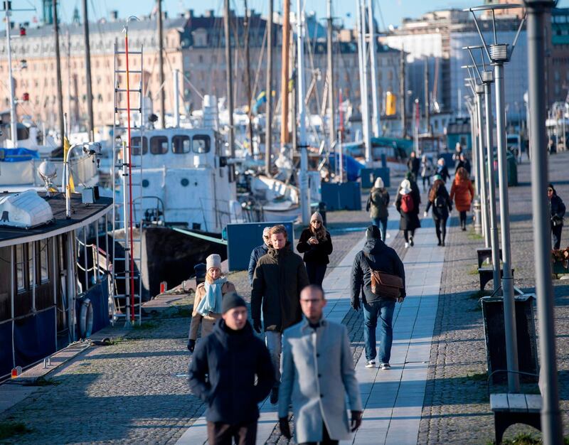 People stroll in the cold but sunny weather along Standvagen quayside in Stockholm, Sweden, on November 20, 2020, amid the ongoing coronavirus pandemic. Sweden OUT
 / AFP / TT News Agency / Fredrik SANDBERG
