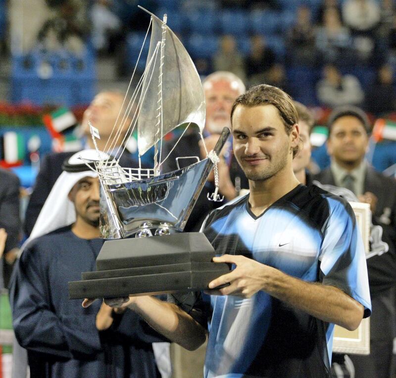 Top-seeded Roger Federer of Switzerland, 21, shows the trophy of the Dubai Open after beating third-seeded Jiri Novak of Czech 6-1, 7-6, (7/2) during the final match to win the one-million-dollar tournament 02 March 2003 in Dubai. AFP PHOTO/Rabih MOGRABI (Photo by RABIH MOGHRABI / AFP)