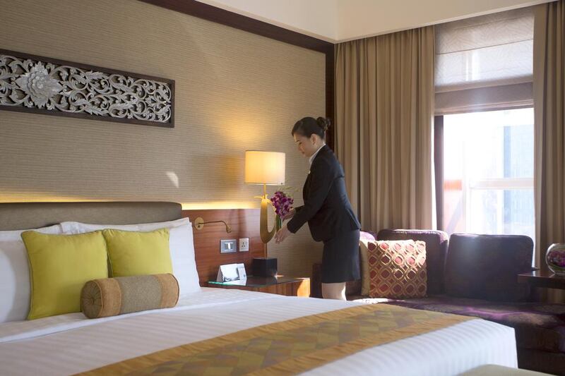 A staff sets out fresh flowers in Dusit Thani's Executive Suite in preparation for guests. Clint McLean for The National