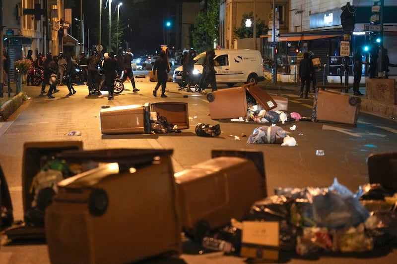 Protesters block a street with bins in Colombes.  AP