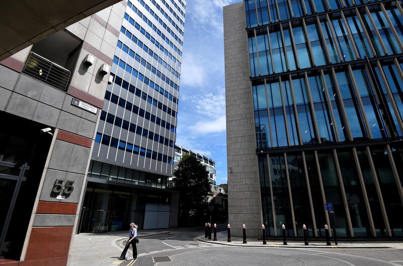 FILE PHOTO: A woman walks through the financial district in the City of London, following the outbreak of the coronavirus disease (COVID-19), in London, Britain July 13, 2020. REUTERS/Toby Melville/File Photo