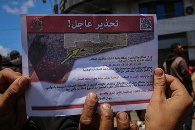 Palestinians show a leaflet dropped by Israeli aircraft warning them to evacuate Rafah. Bloomberg