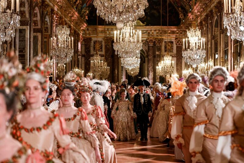 Guests wearing baroque style costumes take part in a ball in the Hall of Mirrors at the Chateau de Versailles Palace as part of the sixth edition's of the Fetes Galantes fancy dress evening which theme is the Royal Wedding of Marie Antoinette and Louis XVI, in Versailles on May 23, 2022.  - The annual fancy dress ball aims to re-create the baroque splendour of the Sun King's dazzling court feasts held to show off the wealth and power of France's longest-reigning monarch.  For tickets costing more than five hundred euros, guests can wander through the private apartments of the chateau, which is a World Heritage site and one of France's biggest tourist attractions.  (Photo by Ludovic MARIN  /  AFP)