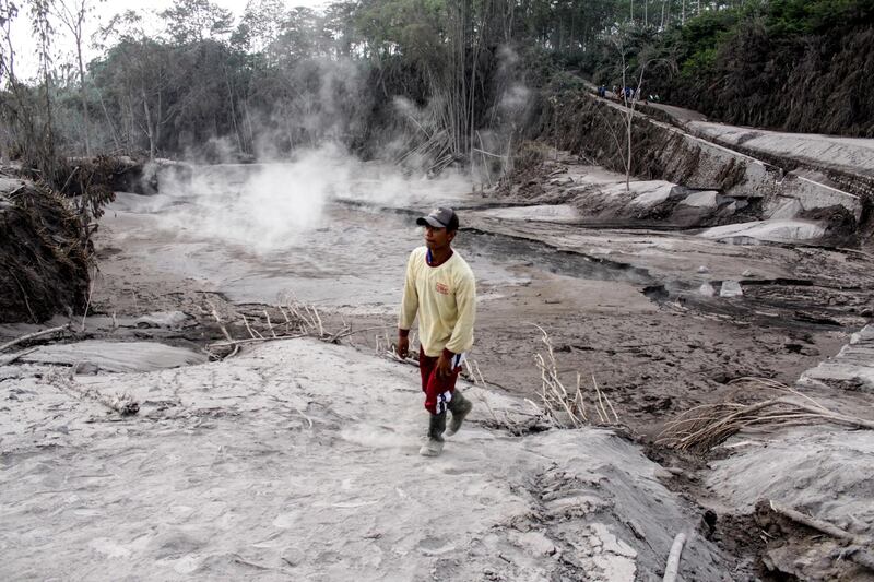 A man walks on a road blanketed with volcanic ash from the erupting Mount Semeru in Lumajang, East Java Province, Indonesia. Reuters