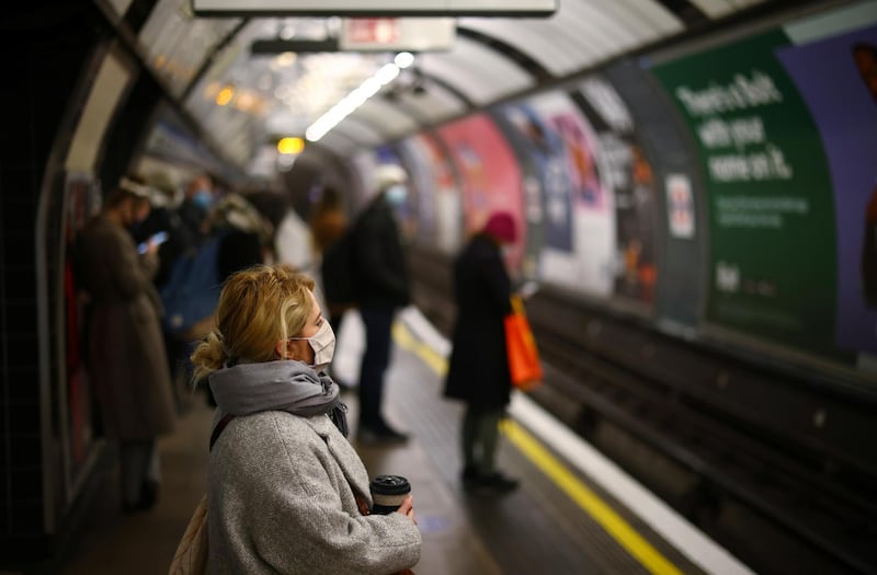 A woman wearing a face mask and holding a cup looks on at the Vauxhall tube station amid the coronavirus disease (COVID-19) outbreak, in London, Britain January 12, 2021. REUTERS/Henry Nicholls