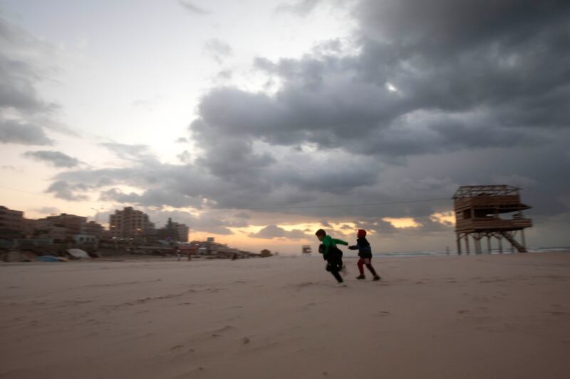 Two Palestinian children run during sunset on the beach during stormy weather in Gaza city. AP