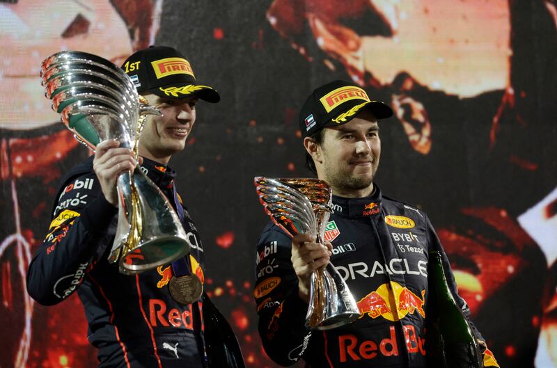 Red Bull's Max Verstappen celebrates on the podium after winning the Abu Dhabi Grand Prix alongside third-placed teammate Sergio Perez at Yas Marina Circuit on Sunday, November 20, 2022. Reuters