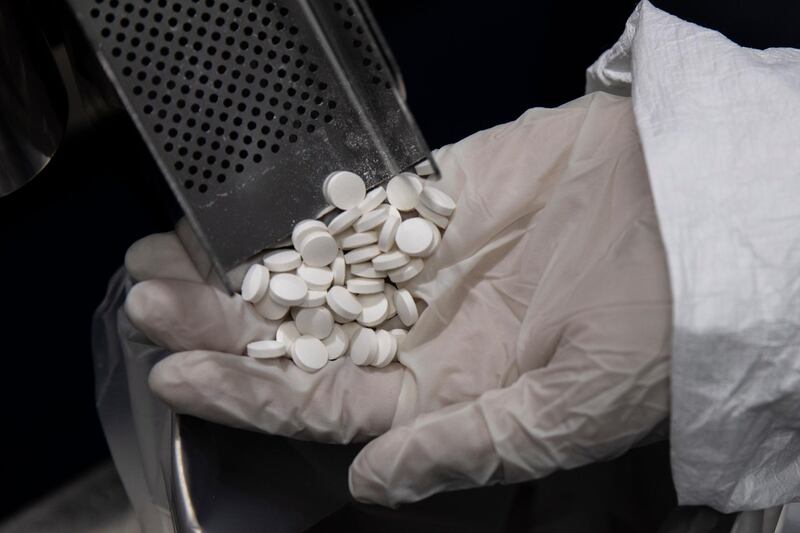 A lab technician holds avipiravir medication used to treat coronavirus, at the Eva Pharma facility in Cairo, Egypt. AP Photo