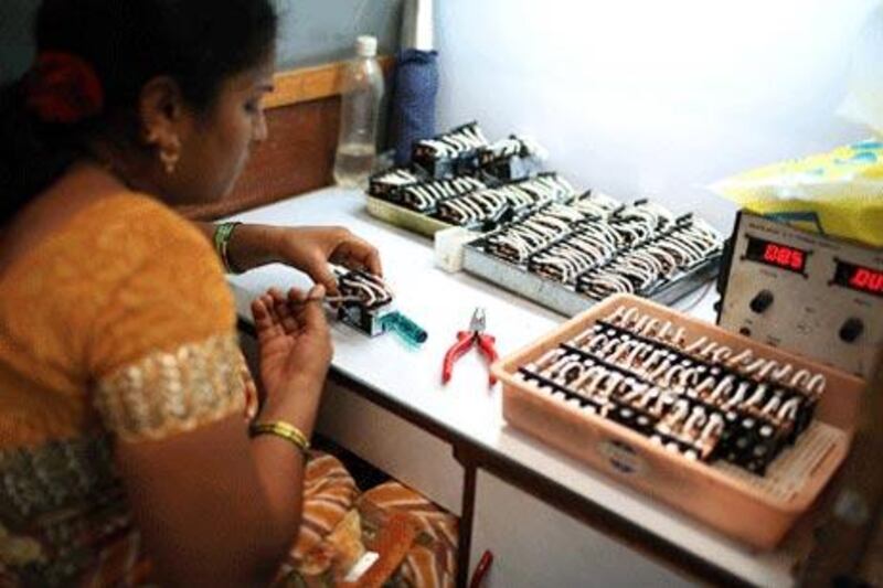 A worker assembles relays at Tara Relays, a small-scale manufacturer in India. Cheap Chinese imports have hurt the firm's business.