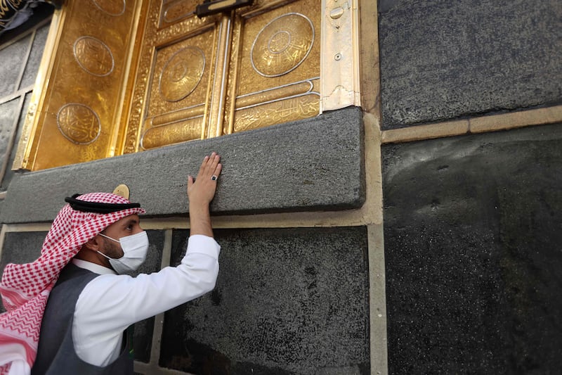 A Muslim worshipper touches the Kaaba. AFP