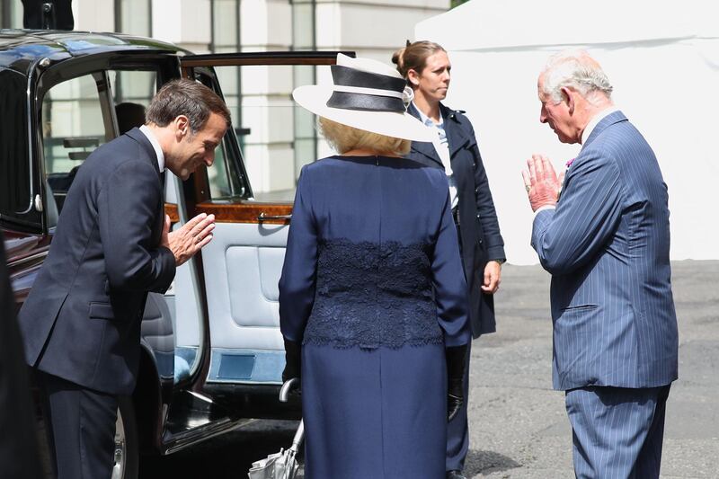 French president Emmanuel Macron says goodbye with a namaste gesture to the Britain's Prince Charles, Prince of Wales, right, and Britain's Camilla, Duchess of Cornwall after a ceremony at the statue of former French president Charles de Gaulle at Carlton Gardens in central London. AFP