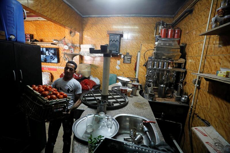 A worker carries tomatoes at a cafe that has been transformed into a vegetable shop, in Cairo, Egypt. Reuters