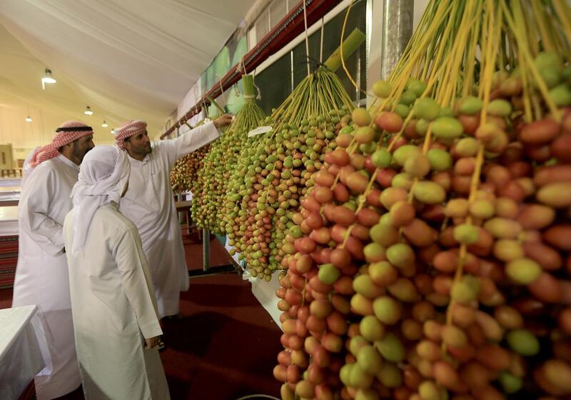 Visitors take a close look at the produce on display on Saturday, the opening day of this year’s Liwa Date Festival. More than three tonnes of dates were entered in the opening round of the competitions. Ravindranath K / The National