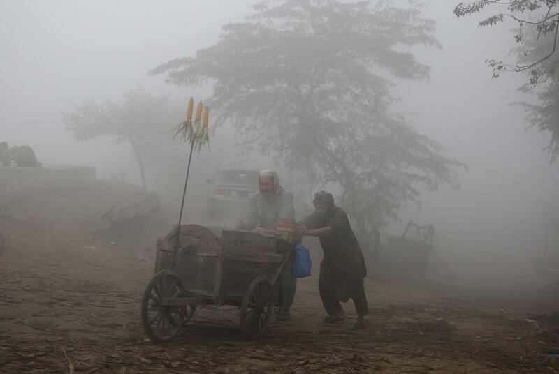 Vendors push their cart during a smoggy day in Lahore, Pakistan. KM Chaudary / AP Photo