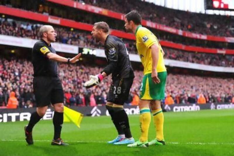 Norwich goalkeeper Mark Bunn and Russell Martin argue with the assistant referee Richard West. Mike Hewitt / Getty Images