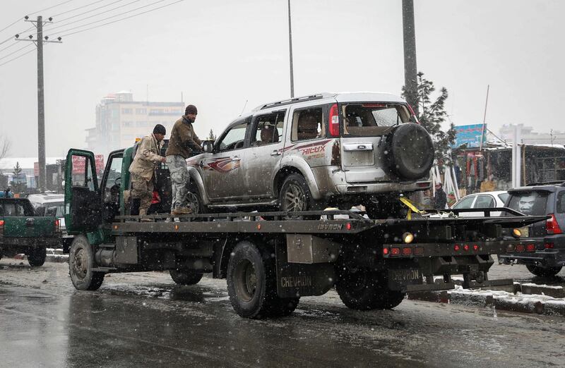 Afghan security forces carry a damaged vehicle from the site of a suicide attack which targeted the entrance gate of Marshal Fahim Military Academy in Kabul, Afghanistan.  EPA