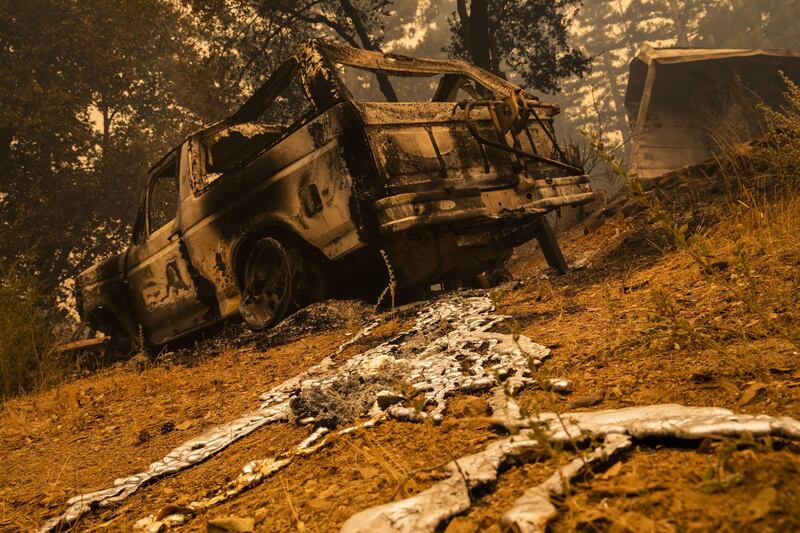 A destroyed vehicle sits amongst the rubble of a burned home along Empire Flat Road. Bloomberg