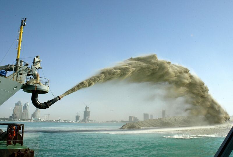 Sand is pumped onto a man-made island part of a $1 billion project in the shape of palm trees off the Dubai coast September 9, 2005. [Thousands of workers from the Indian subcontinent, lured by promises of jobs in the oil-rich United Arab Emirates, toil in scorching heat and high humidity for most of the year. The emirate is fast becoming an architect's playground as more and more outlandish structures take it closer to its dream of being the world's most visually striking metropolis. The infrastructure boom is part of the emirate's ambition to attract foreign cash and investment into an economy that is weaning itself off rapidly-dwindling crude oil reserves.]