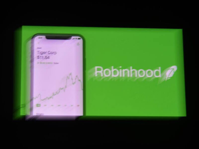 This photo illustration shows the logo of trading application Robinhood on a mobile phone in Arlington, Virginia on January 28, 2021. An epic battle is unfolding on Wall Street, with a cast of characters clashing over the fate of GameStop, a struggling chain of video game retail stores. The conflict has sent GameStop on a stomach-churning ride with amateur investors taking on the financial establishment in the mindset of the Occupy Wall Street movement launched a decade ago.  / AFP / Olivier DOULIERY
