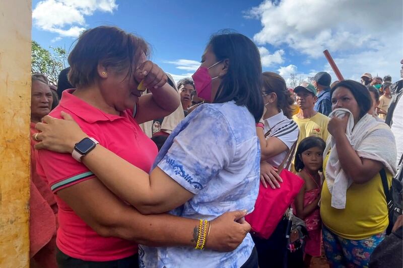 Vice President Leni Robredo, foreground right, comforts a woman after inspecting damage caused by Typhoon Rai on the Dinagat Islands, the Philippines. AP