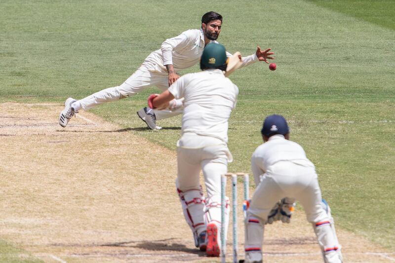 India's Ravindra Jadeja dives to stop the ball of his own bowling during play on day three of the third cricket test between India and Australia in Melbourne, Australia. AP Photo