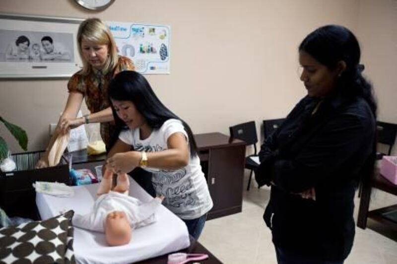 December 1, 2010 - Dubai, UAE - Anne Marpole, a midwife at Infinity Health Clinic, teaches 2 nannies, who did not give their names, how to care for a newborn baby.  The class went over things such as how to change a nappy and how to give a baby a bath.  (Andrew Henderson/The National)