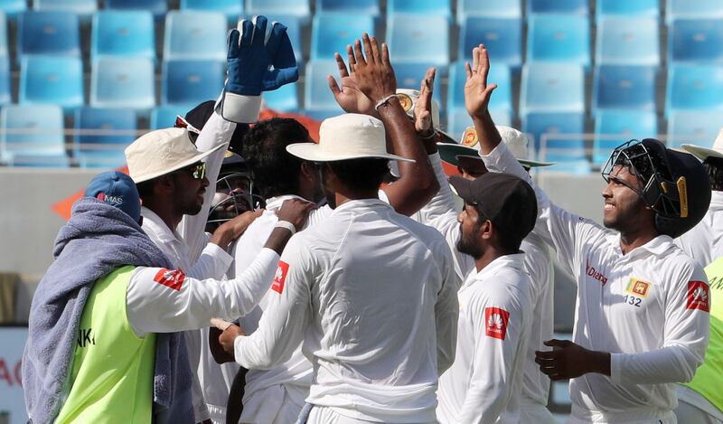 Sri Lanka cricket players celebrate after winning the second Test cricket match between Pakistan and Sri Lanka at Dubai International Cricket Ground in Dubai on October 10, 2017. / AFP PHOTO / KARIM SAHIB