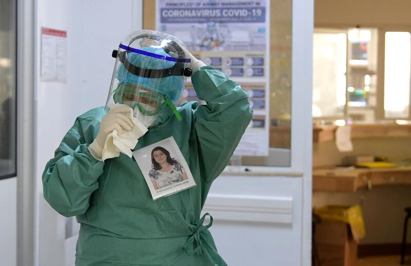 Amira Jamoussi, with a picture of herself pinned on her protective outfit to help others to recognise her, gets ready to see patients at the Abderrahmane Memmi hospital in the city of Ariana north of the Tunisian capital Tunis. AFP