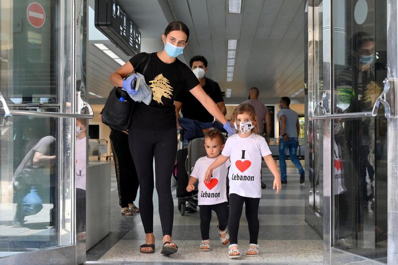 People wearing protective face masks against Covid-19 are pictured upon their arrival at the terminal of the Rafik Hariri International Airport during its re-opening in Beirut. EPA