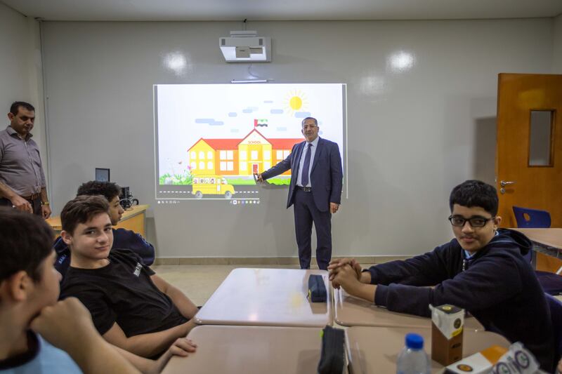Hassan Sabbah, head teacher of Sama American Private School, shows pupils one of the new interactive screens