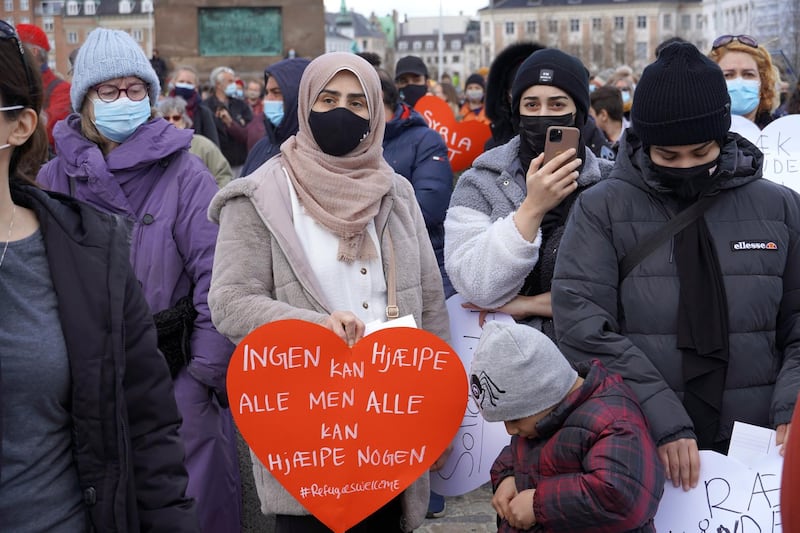 COPENHAGEN, DENMARK - APRIL 21: People along with a number of activists gather to protest the government's plan to deport Syrian refugees after Denmark refused to renew residency permits of Syrian refugees, as protest held by Mellemfolkelig Samvirke (Action Aid), Youth Branch of the Danish Refugee Council, Venligboerne and Syrian activist Haifaa Awad at Christiansborg Palace square near parliament building ,in Copenhagen, Denmark on April 21, 2021. (Photo by Davut Colak/Anadolu Agency via Getty Images)