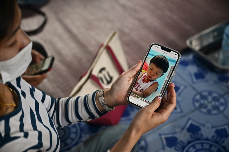 Sujittra Pornikhom, mother of three-year-old Nannaphat "Stamp" Songserm, shows a photograph of him on her mobile phone in their home in Na Klang in Thailand's northeastern Nong Bua Lam Phu province. AFP