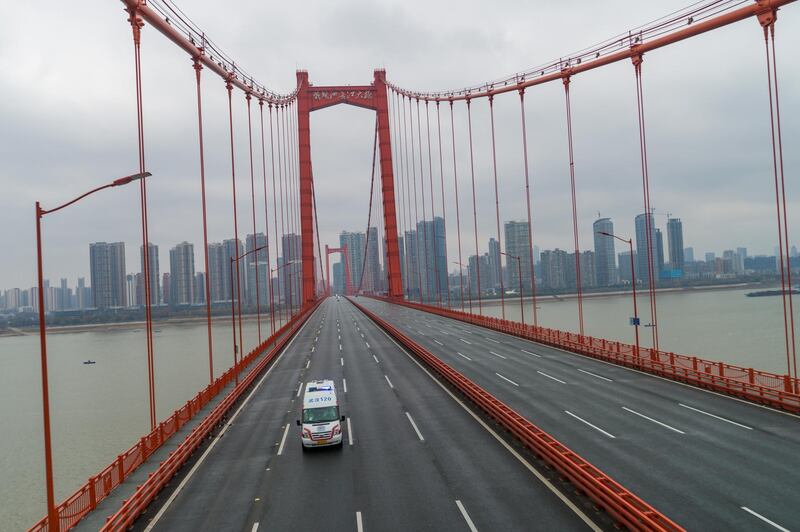 An ambulance runs on an empty bridge in Wuhan, Hubei province, China.  EPA