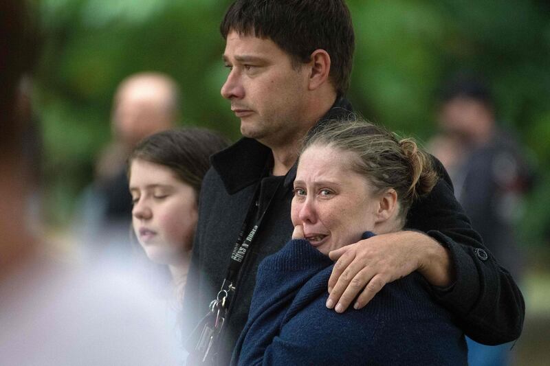 Members of the public show emotion standing across the road from the Dean Avenue mosque on March 17, 2019 in Christchurch. AFP