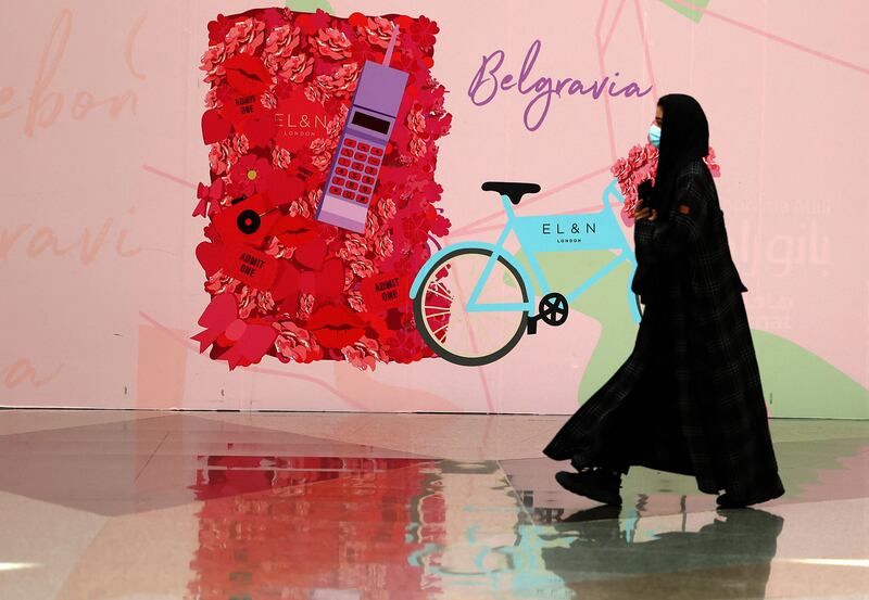 A woman walks past an advertisement featuring red hearts and flowers in Panorama mall in Riyadh on February 9, 2022. AFP